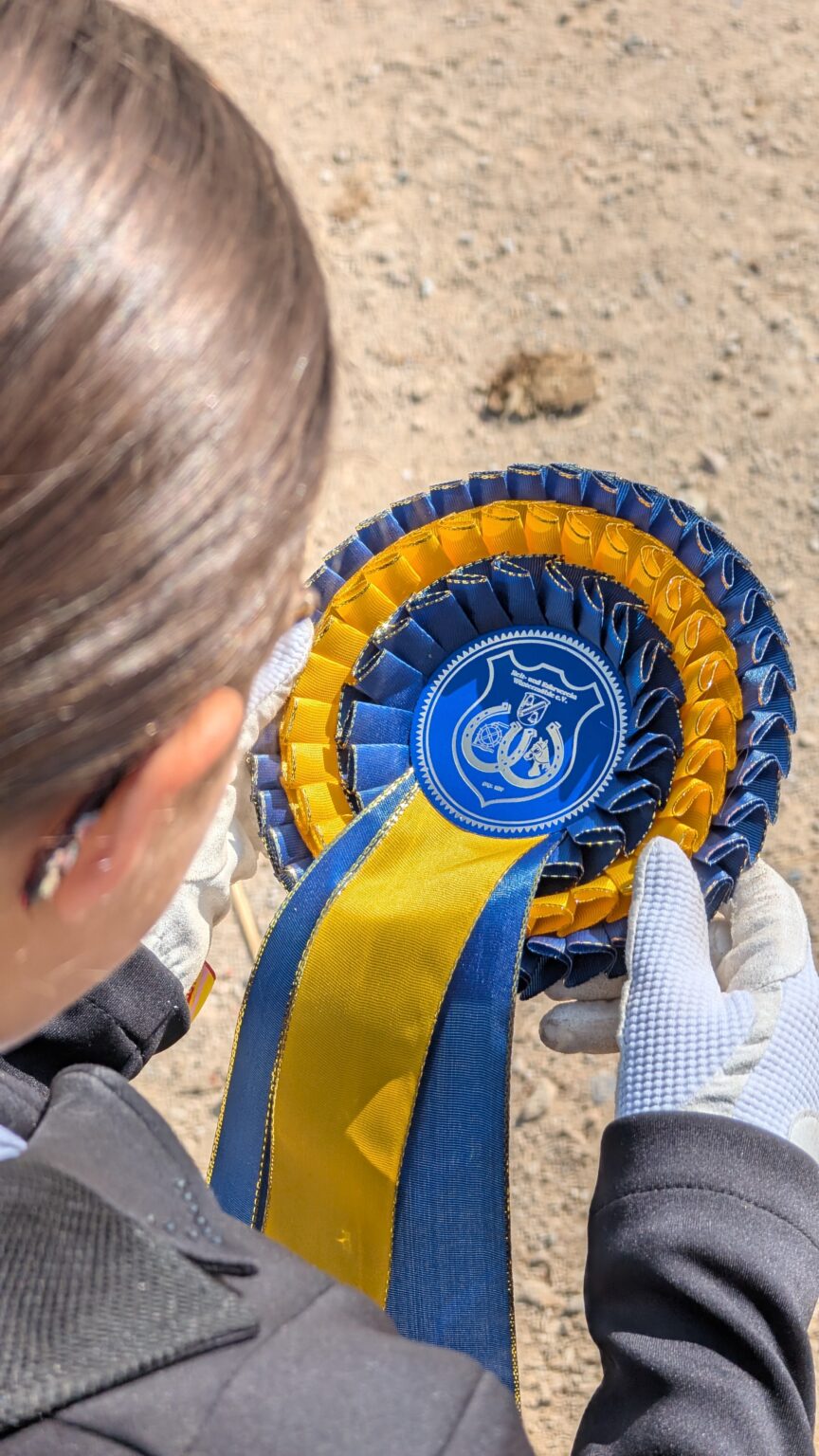 Die Reiterin mit der Trophäe für den ersten Platz in der Hand